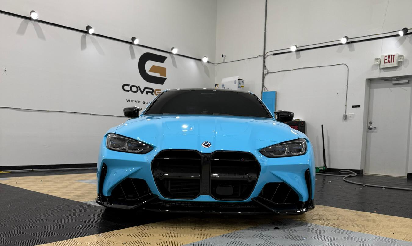 Sky-blue BMW with ceramic window tint in front of the CovrGard wall at Taggart Films in Christiana, Delaware